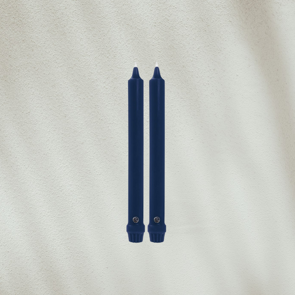 Two dark blue candles on a light gray background